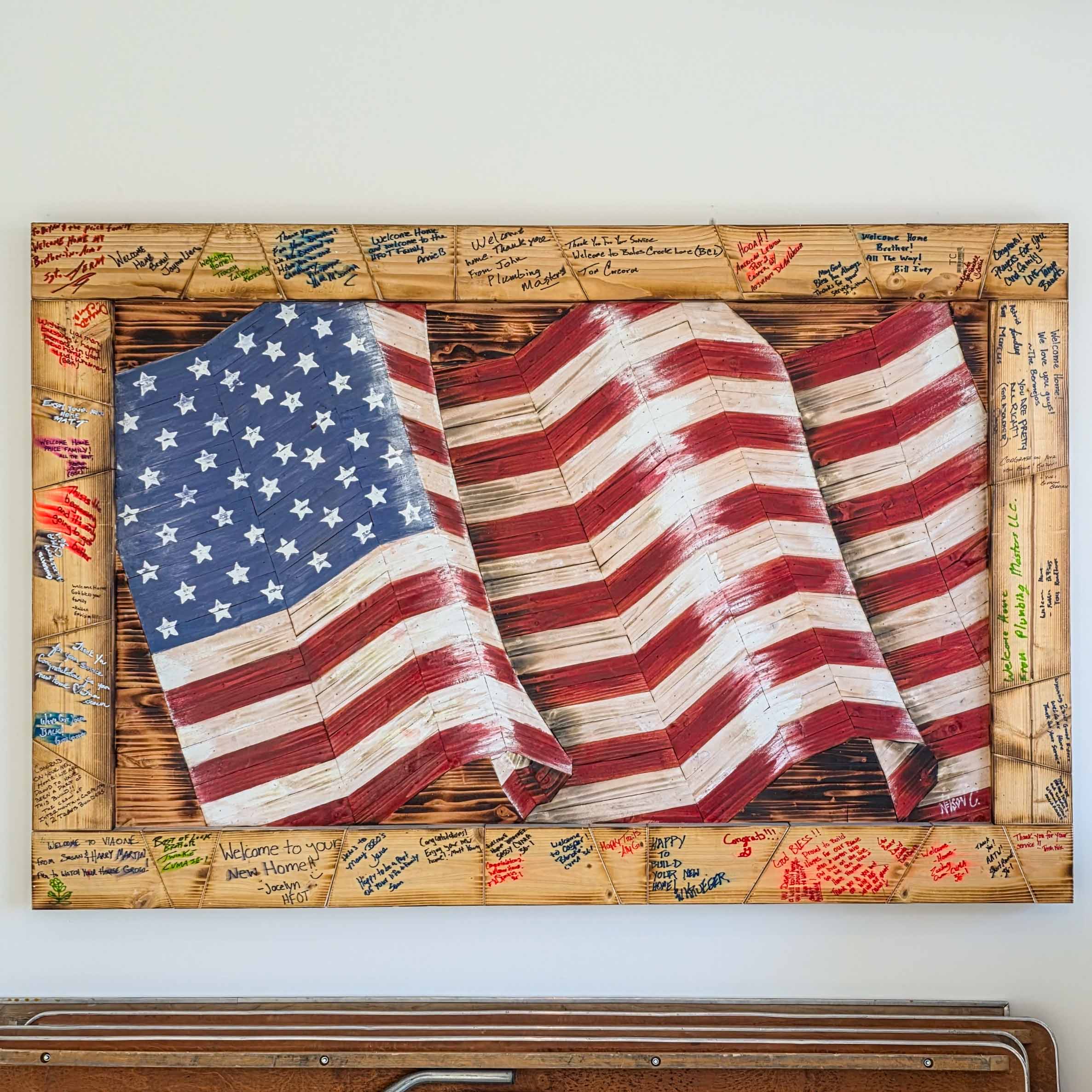 Our Lead Carpenter, Nelson, painted and built a wooden flag at all Homes For Our Troops Homes using 2x4's that the community wrote kind words on.