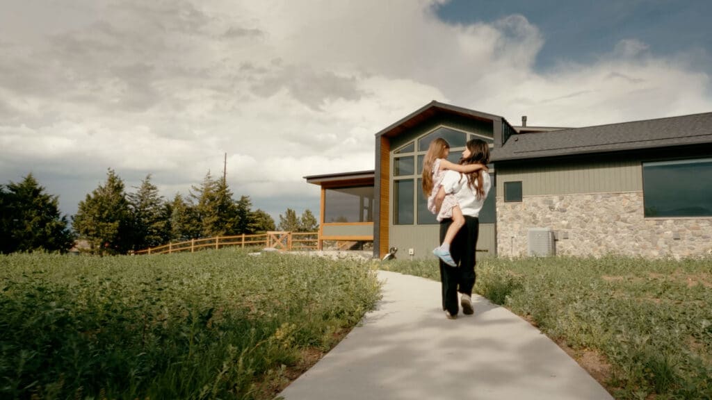 A woman and child walking towards a Built By Krueger Home