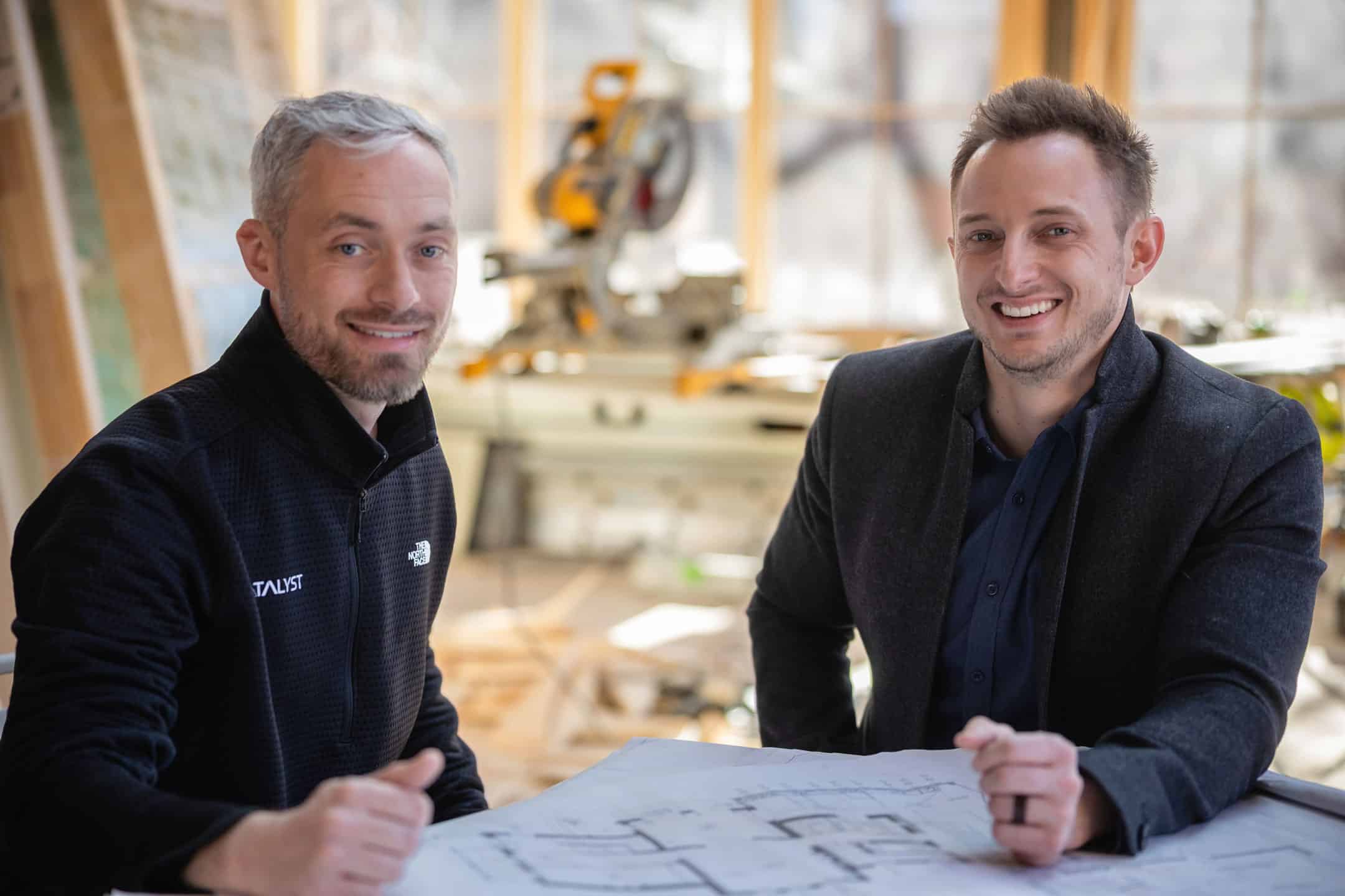 Seth Donnell and Anthony Gengaro co founders of Catalyst Architecture sitting at a table looking at plans.